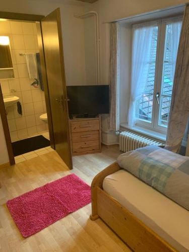 ein Schlafzimmer mit einem Bett und ein Badezimmer mit Dusche in der Unterkunft Gasthaus zum Bären in Bözen