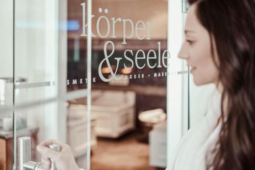 a woman looking in the window of a store at Hotel St. Georg zum See in Maurach