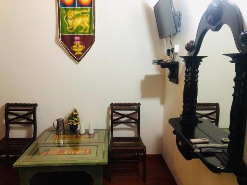 a dining room with a table and a shield on the wall at Hareesha Holiday Resort in Galle