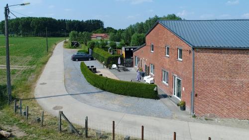a road next to a brick building with a car at DE SMISHOEVE met kinderpret, dieren en wellness in Heers