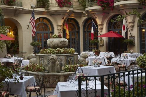 a restaurant with white tables and chairs and a fountain at The Mission Inn Hotel and Spa in Riverside