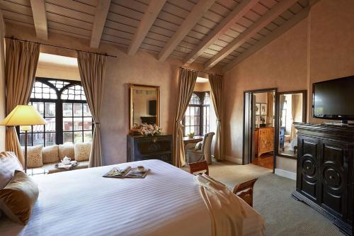 a bedroom with a large bed and a television at The Mission Inn Hotel and Spa in Riverside
