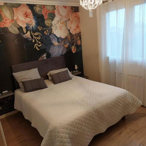 - une chambre avec un grand lit et du papier peint floral dans l'établissement Villa de charme avec piscine, à Saint-Jory