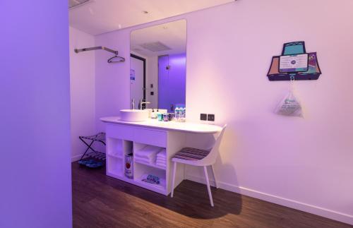 a bathroom with a white sink and a mirror at SOJO HOTEL DAK LAK in Buon Ma Thuot