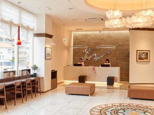 a lobby of a restaurant with two people standing at a counter at Grand Cabin Hotel Naha Oroku in Naha