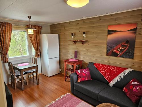 ein Wohnzimmer mit einem Sofa und einem Kühlschrank in der Unterkunft Holiday Village Nuorgamin Lomakeskus in Nuorgam
