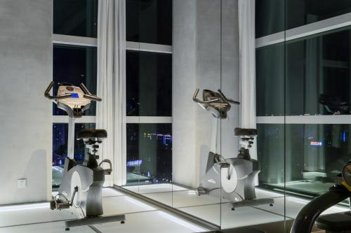a gym with exercise equipment in front of a window at Pagoda Hotel Shenzhen Familytrip&BusinessTravel in Shenzhen