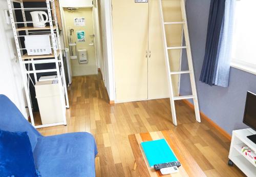 a living room with bunk beds and a blue couch at グレース大磯 in Oiso
