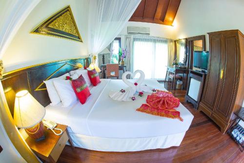 a bedroom with a large white bed with decorations on it at Golden Pine Resort and Spa in Ban Du