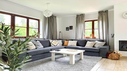 a living room with a blue couch and a table at Domy nad Jeziorem Sun & Snow Osada Zamkowa in Pasym