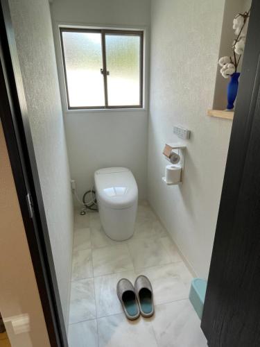 a bathroom with a toilet and a pair of shoes at Boss'sHouse 犬ok 1組限定の宿 in Kirishima