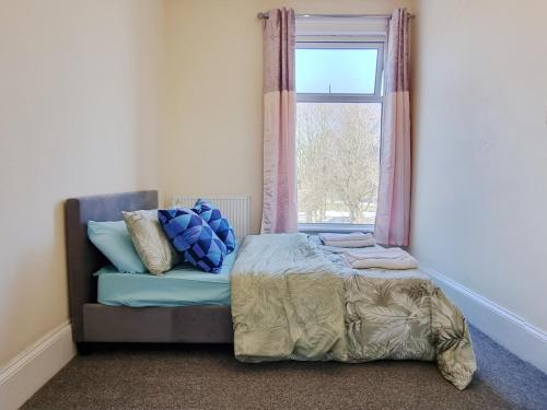 1 dormitorio con cama y ventana en 2 Bedroom 4 Beds Family Flat Free Parking & Fast Wi-Fi Self-Check-in Cosy & Spacious en Rochdale