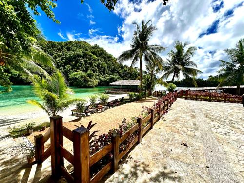 a beach with a wooden fence and the water at Sea Passion Hotel in Koror