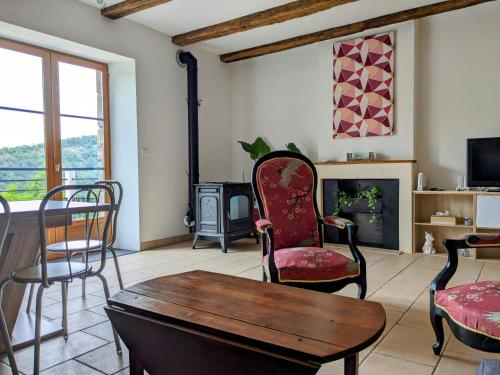 a living room with chairs and a table and a fireplace at Le Quatorze, au cœur de Najac in Najac
