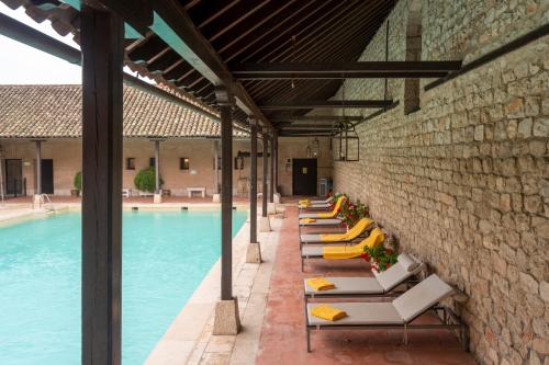 a row of lounge chairs next to a swimming pool at Parador de Chinchón in Chinchón