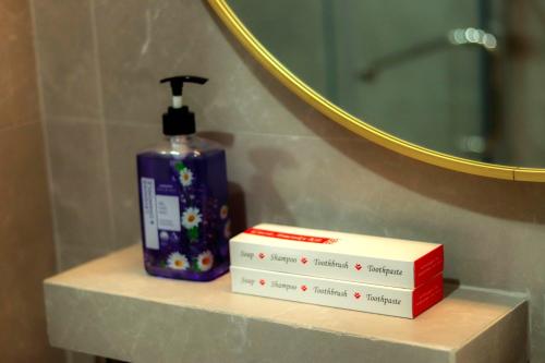 a bottle of soap sitting on a shelf in a bathroom at Gloria Tree Mayon and Park View Residences in Legazpi