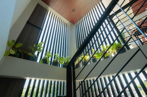 a staircase with plants in a house at Gloria Tree Mayon and Park View Residences in Legazpi