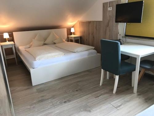 a bedroom with a bed and a desk with a computer at Abendruhe Hotel - kontaktloser Check In in Oberhaching