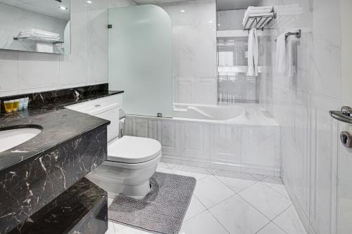 a white bathroom with a toilet and a sink at Stunning sew view apartment in JBR in Dubai