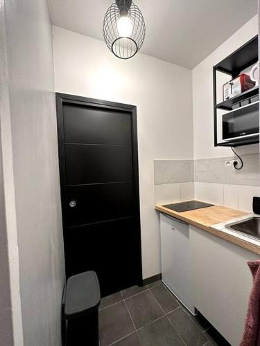 Una puerta negra en una cocina con encimera en Appartement GARE Juvisy*ORLY AIRPORT*Paris en Juvisy-sur-Orge
