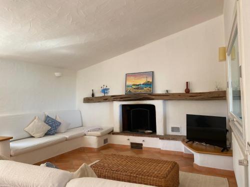 a living room with a couch and a fireplace at Villa Belinda in Santa Margherita di Pula