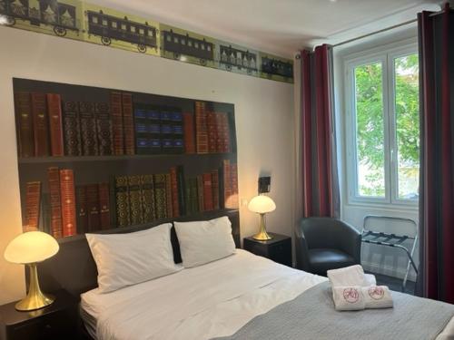 a bedroom with a bed with books on the wall at Hôtel Les Voyageurs in Bastia