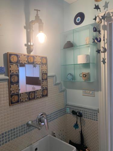 La salle de bains est pourvue d'un lavabo et d'un miroir. dans l'établissement Il nido dell’albatros, à Formia