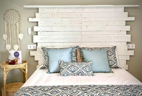 una camera da letto con testiera bianca e cuscini su un letto di MyChoice Alegria by Bossh! Apartments a Rota