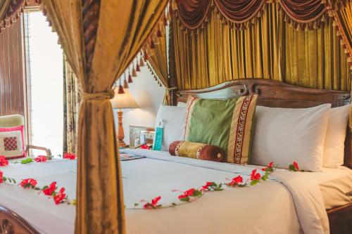 a bedroom with a canopy bed with red flowers on it at Le Meridien Jaipur Resort & Spa in Jaipur