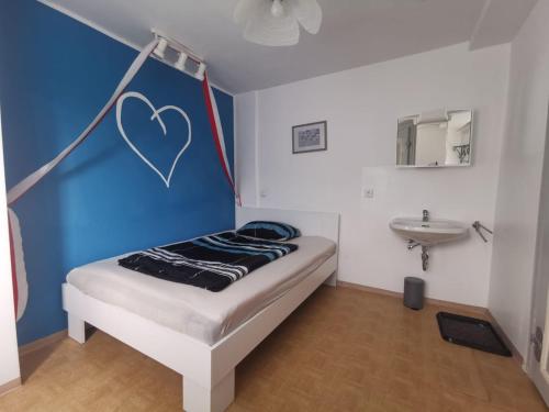 ein Schlafzimmer mit einem Bett mit einem an der Wand gemalten Herz in der Unterkunft Gästehaus am Rathaus in Pottenstein
