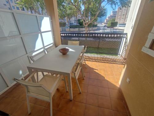 a table and chairs on a balcony with a view at Apartamento con piscina y cerca de la playa in Canet de Berenguer