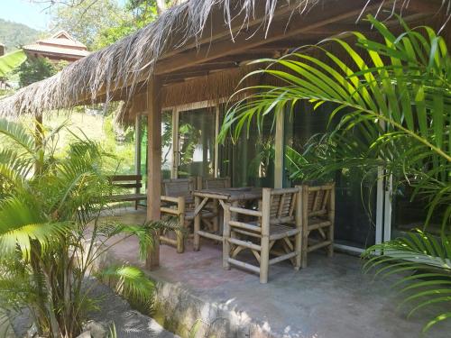 a porch of a house with a table and chairs at RED PEARL BEACH RESORT in Chaloklum