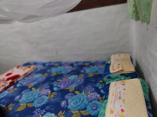 a bed with a floral bedspread and two ties at BenTrestay in Giồng Tú Ðiền