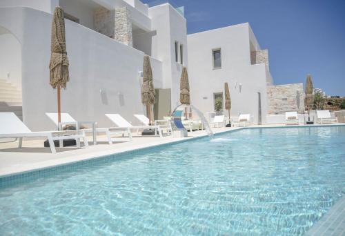 - une piscine avec des chaises et des parasols à côté d'un bâtiment dans l'établissement ANEMOLETHE, à Kimolos