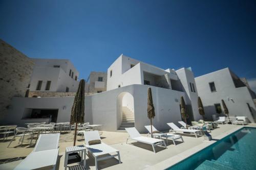 a resort with a pool and chairs and a building at ANEMOLETHE in Kimolos