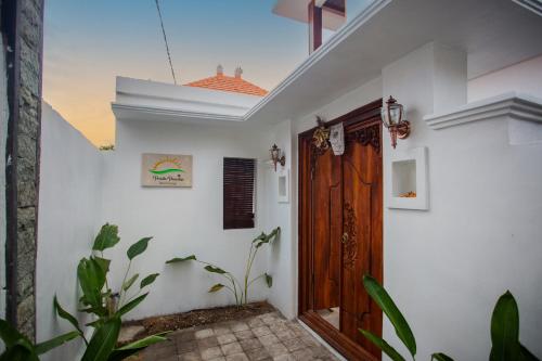 una camera con pareti bianche e porta in legno di Penida Paradiso a Klungkung