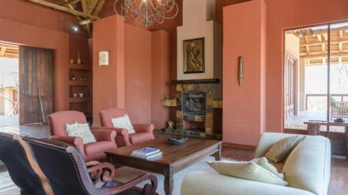 a living room with orange walls and a table and chairs at 203 Zebula - 5 Bedroom 20 sleeper in Mabula
