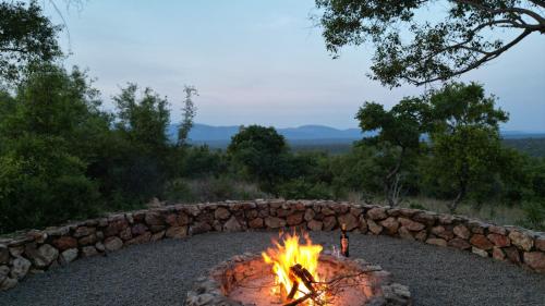 a fire pit in front of a stone wall at 203 Zebula - 5 Bedroom 20 sleeper in Mabula
