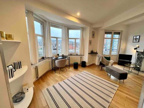 a living room with windows and a rug at Bellevue - Sur les quais de la Meuse in Liège