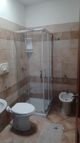 ein Badezimmer mit Dusche, Toilette und Waschbecken in der Unterkunft Residence Ginevra-Porto Miggiano in Santa Cesarea Terme