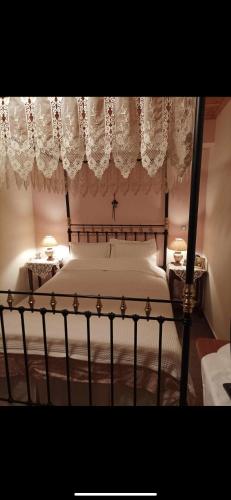 a bedroom with a canopy bed with lace curtains at SEA HOUSE KOUKOULEIKA in Milina