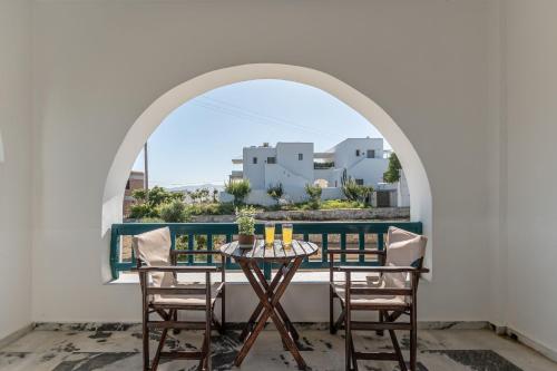 a table and chairs on a balcony with a view at Golden Silence Studios in Agios Prokopios