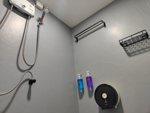 a shower in a room with two bottles on the wall at Met A Space Pod @Phrom Phong in Bangkok