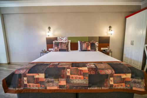 a bedroom with a large bed with a quilt on it at La Vie Konak Otel in Eskisehir