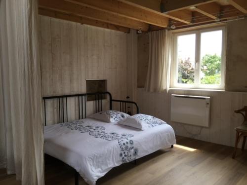 a bedroom with a bed and a window at Loft Sud-Nantes in Le Bignon