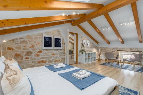 a bedroom with a bed and a stone wall at Apartments Agata in Novigrad Istria