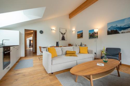 sala de estar con sofá blanco y mesa en Montela Hotel & Resort - Suiten en Saas-Grund