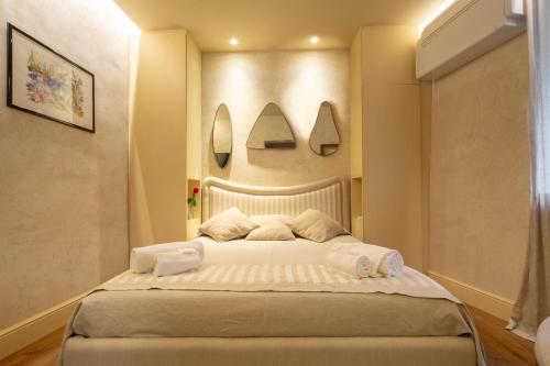 um quarto com uma cama grande e dois espelhos na parede em Serragli Apartment em Florença