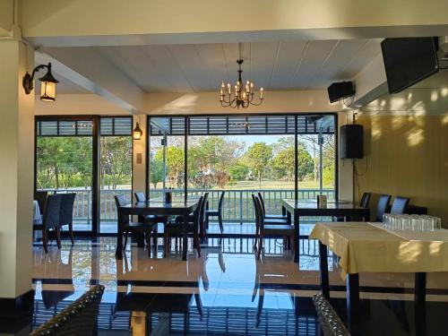 a dining room with tables and chairs and a large window at แกรนด์ ฟอเรสท์ Grand Forest in Chanthaburi