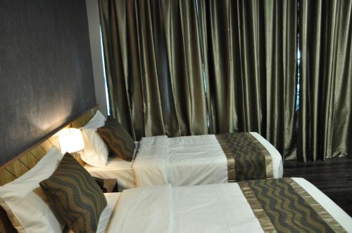 a hotel room with two beds and a window at Valya Hotel, Kuala Terengganu in Kuala Terengganu